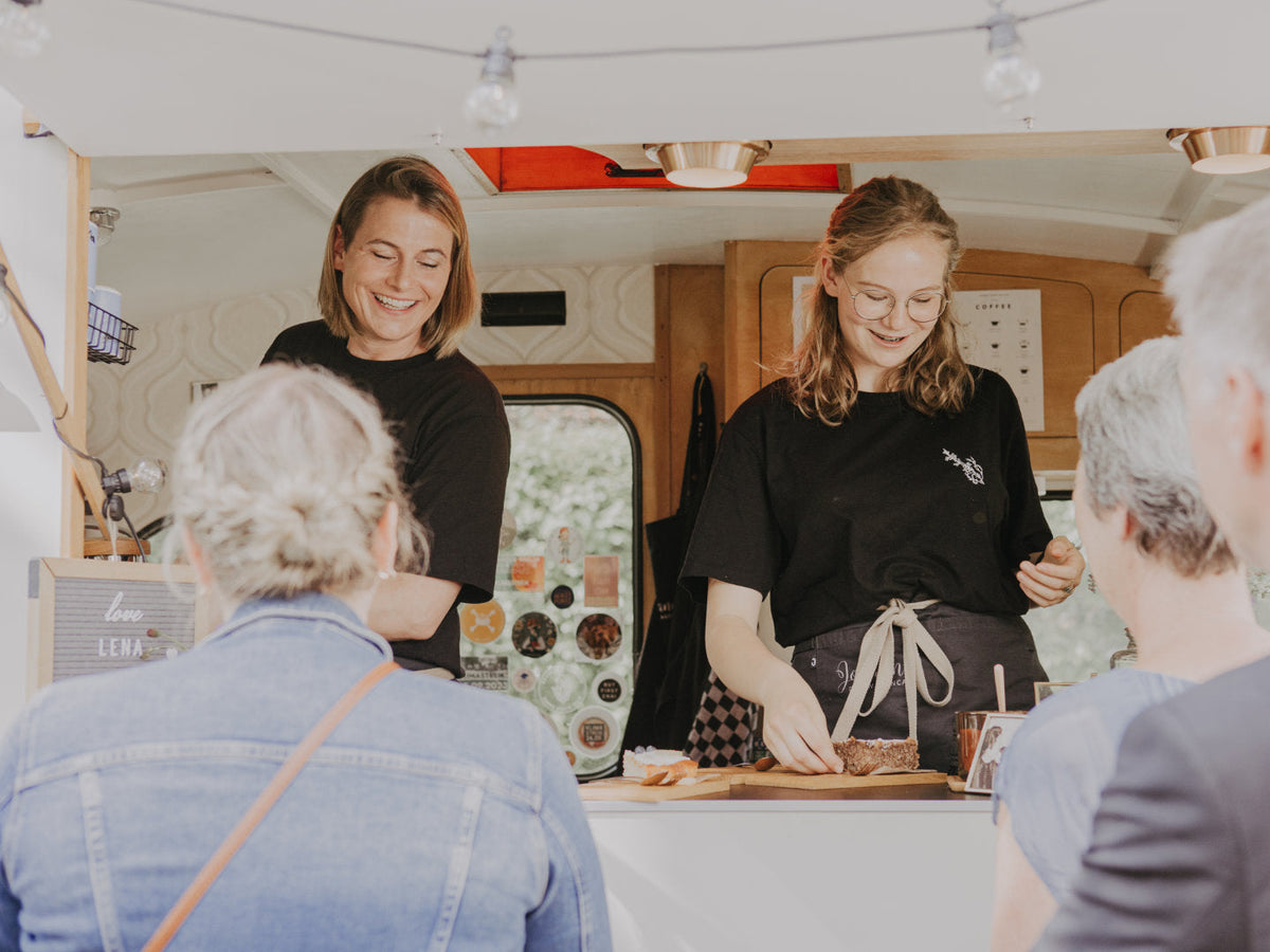 Carina und eine Mitarbeiterin von Johanna das Wagencafe bedienen Kundinnen.