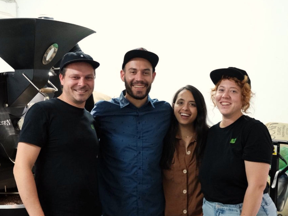 Titelbild zum Blogartikel über Nikolai Fürst. Zu sehen sind Philip Weller, Nikolai Fürst, Manuela Vásquez und Sandy Gruhle in der Rösterei der Günter Coffee Roasters.
