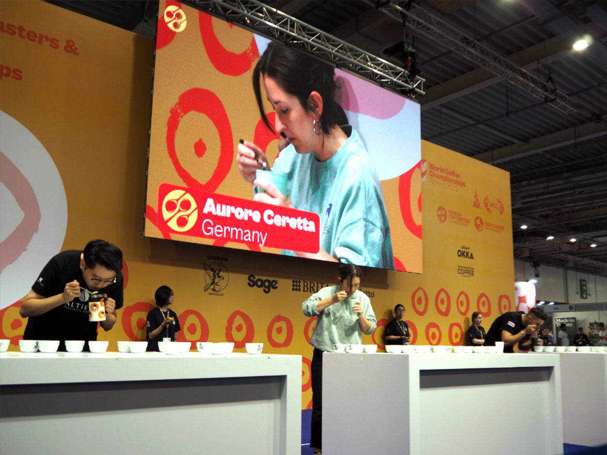 Titelbild zum Blogartikel über die World Coffee Championships. Zu sehen ist Inhaberin der Günter Coffee Roasters Aurore Ceretta bei ihrem Auftritt bei den World Cup Tasters Championships.